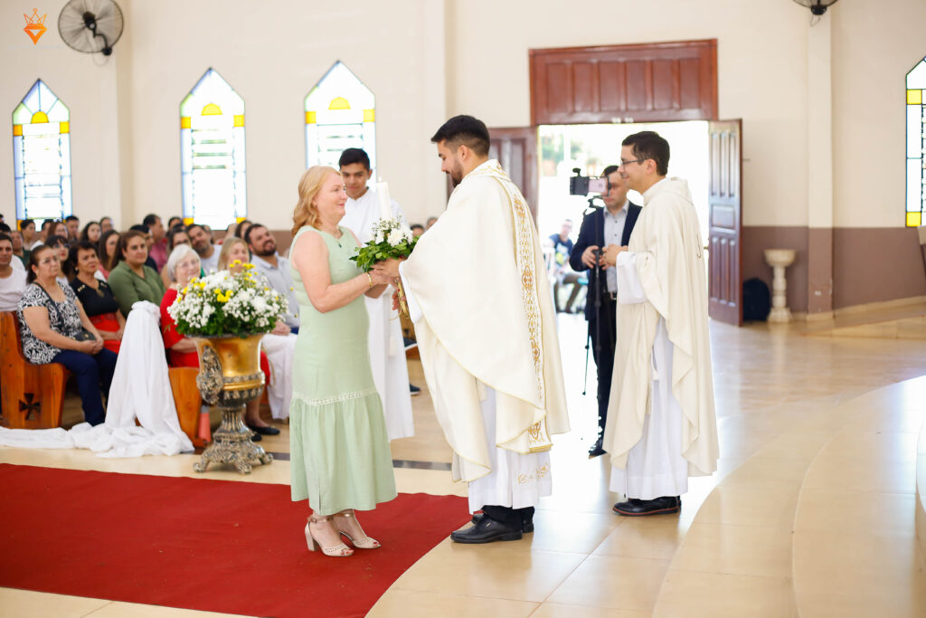 El Padre Luis Bruno Ferreira Arndt recibiendo un ramo de flores.